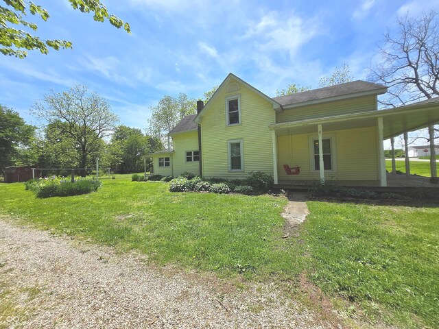 7561 N Hall School Rd, Monrovia, IN 46157 - back of property featuring a yard, a chimney, a porch, and roof with shingles