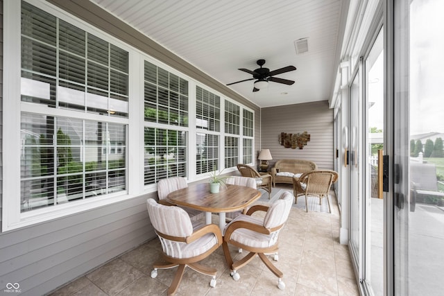 sunroom / solarium featuring healthy amount of natural light and ceiling fan