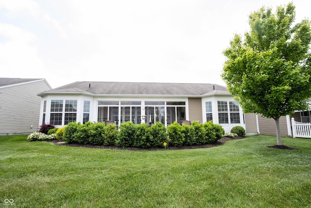rear view of property featuring a lawn