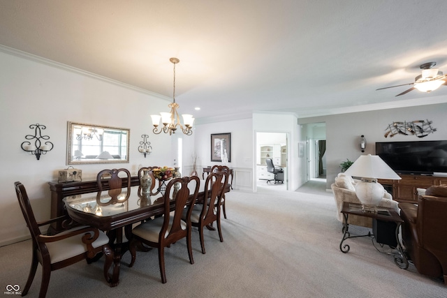 dining area featuring crown molding, light colored carpet, a chandelier, and ceiling fan