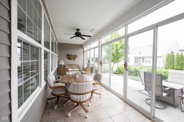 sunroom / solarium featuring ceiling fan, outdoor dining area, and tile patterned flooring