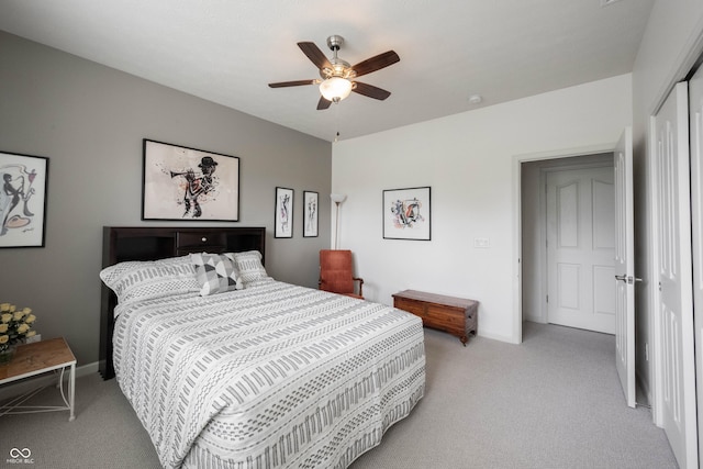 bedroom with light carpet, baseboards, a closet, and ceiling fan