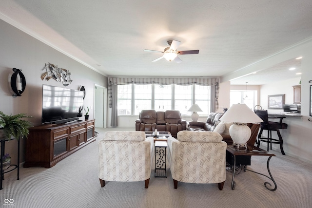 living area featuring a ceiling fan, light colored carpet, and ornamental molding