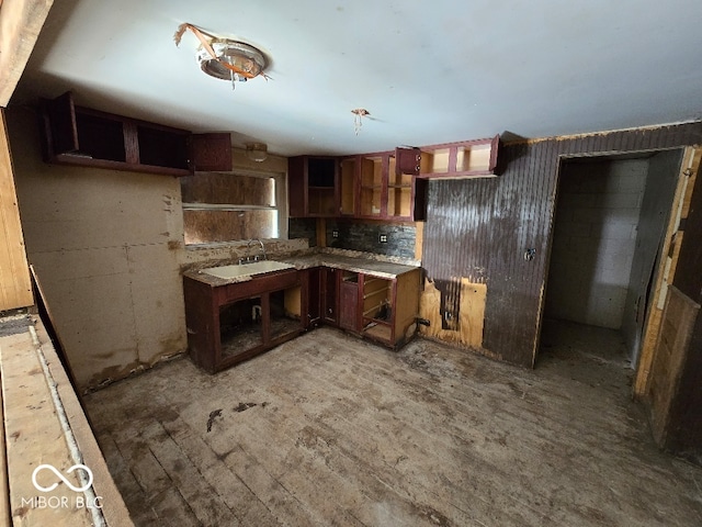 kitchen with tasteful backsplash, light wood finished floors, and a sink