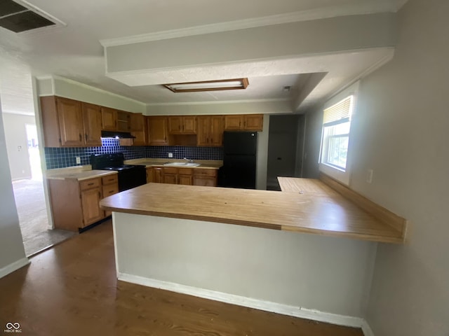 kitchen with light countertops, black appliances, a sink, visible vents, and a peninsula
