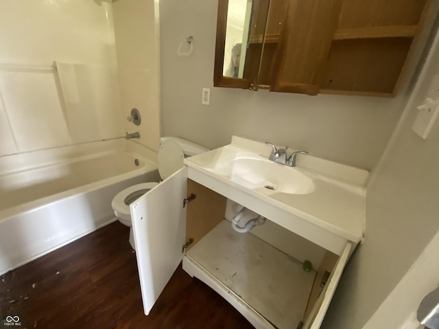 full bathroom featuring wood finished floors, toilet, washtub / shower combination, and a sink