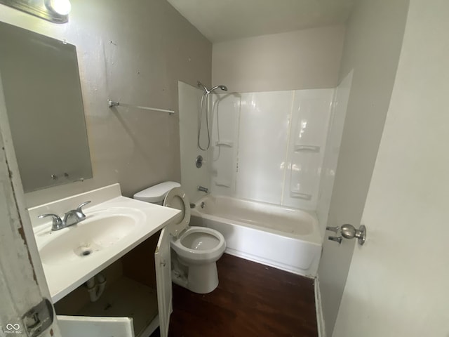 full bath with shower / tub combination, wood finished floors, toilet, and vanity