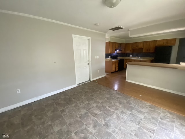 kitchen with brown cabinets, decorative backsplash, refrigerator, and baseboards