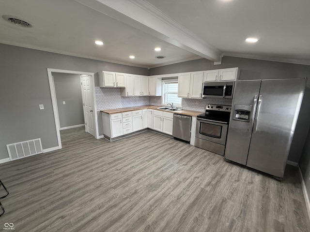 kitchen featuring visible vents, stainless steel appliances, decorative backsplash, and a sink