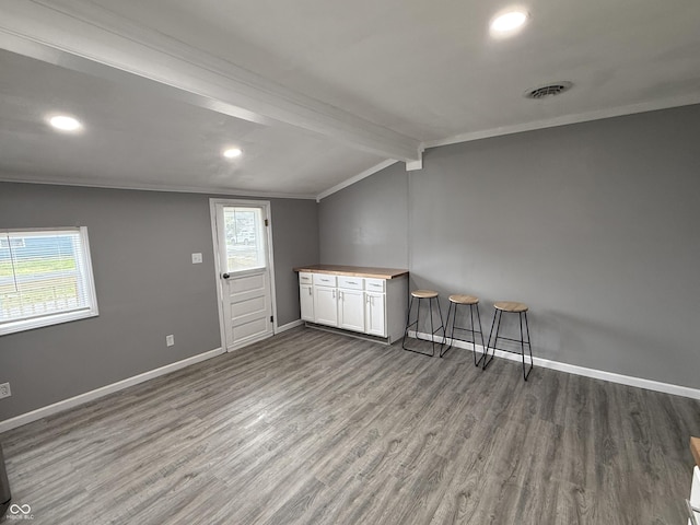 interior space with recessed lighting, lofted ceiling with beams, visible vents, baseboards, and wood finished floors