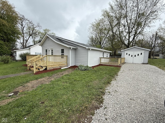exterior space with gravel driveway, an outdoor structure, a garage, a wooden deck, and a lawn