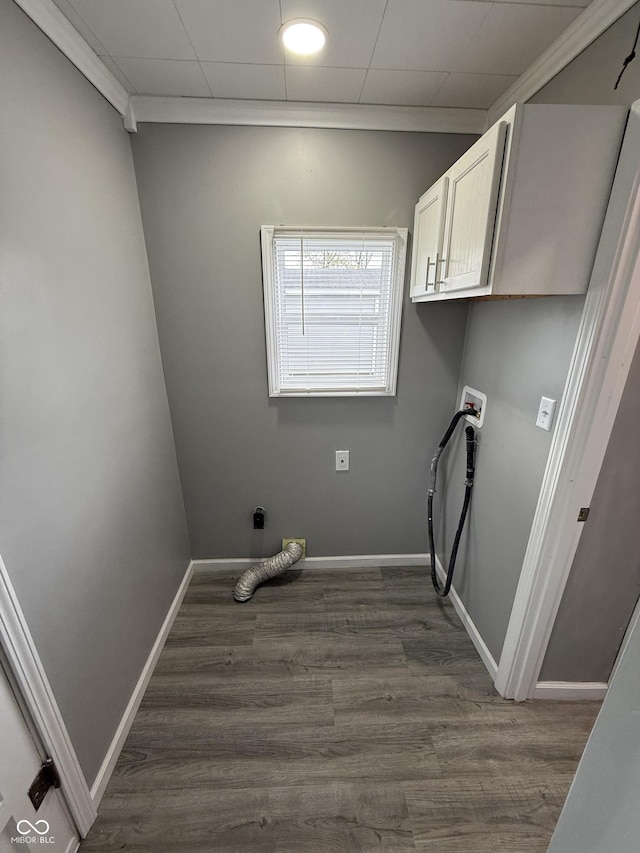 laundry area featuring baseboards, cabinet space, and dark wood-type flooring