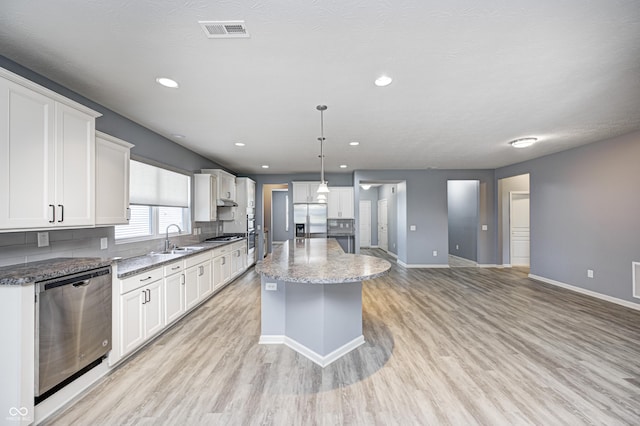 5110 Lilium Dr, Plainfield, IN 46168 - kitchen with appliances with stainless steel finishes, light wood finished floors, white cabinets, a center island, and recessed lighting