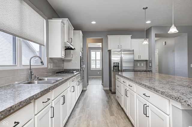 5110 Lilium Dr, Plainfield, IN 46168 - kitchen with appliances with stainless steel finishes, decorative backsplash, light wood finished floors, under cabinet range hood, and recessed lighting