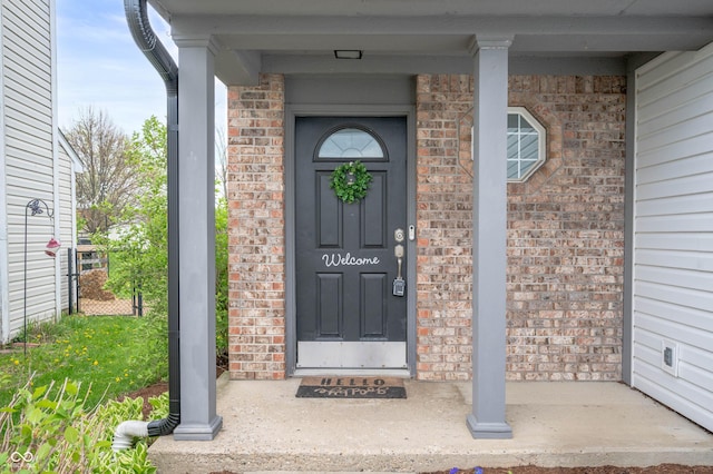 view of exterior entry featuring brick siding