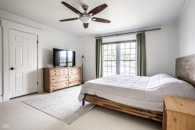bedroom featuring crown molding, a ceiling fan, and wood finished floors