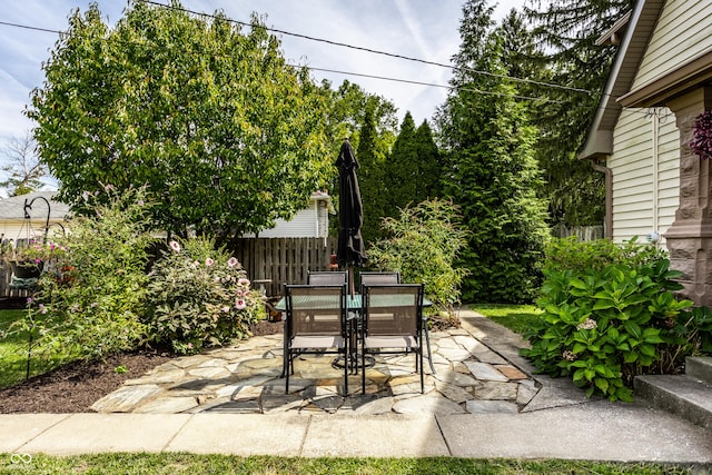 view of patio featuring outdoor dining area and fence