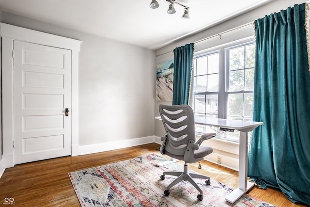 home office with baseboards and wood finished floors