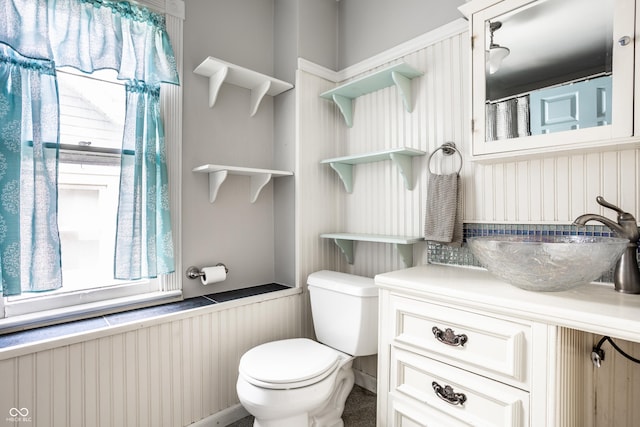 full bathroom with vanity, a wainscoted wall, and toilet