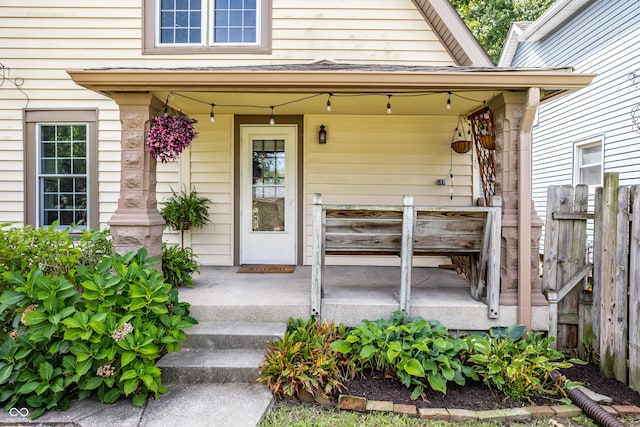 entrance to property featuring fence and a porch