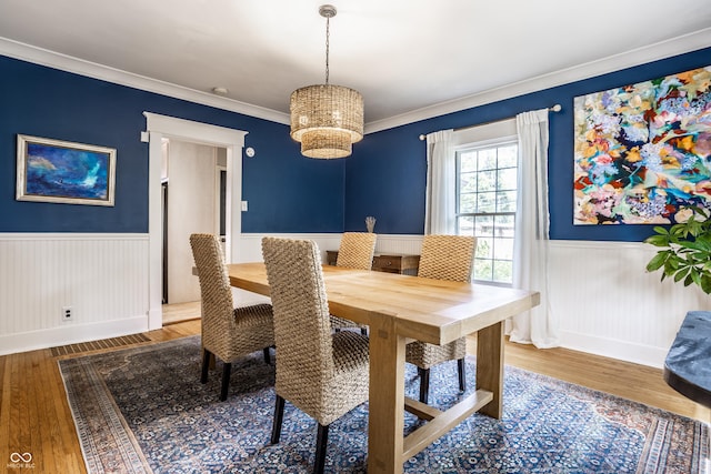 dining room with visible vents, crown molding, wainscoting, wood finished floors, and a chandelier