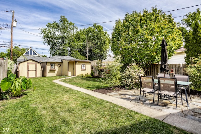 view of yard with a patio, a fenced backyard, an outbuilding, and a storage shed