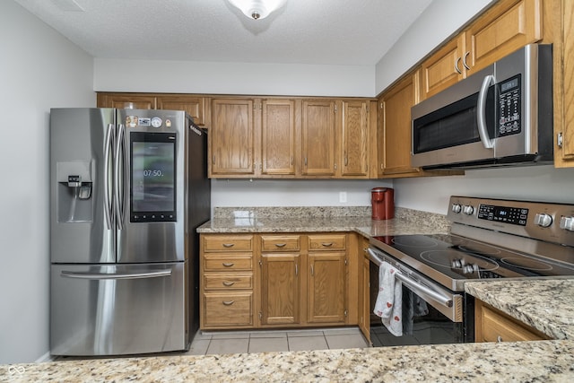 8140 Shorewalk Dr Unit C, Indianapolis, IN 46236 - kitchen with light stone counters, brown cabinetry, stainless steel appliances, and light tile patterned flooring