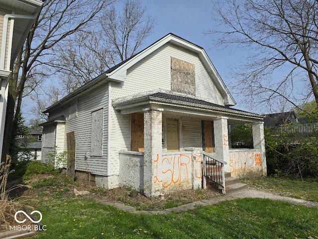 view of front facade featuring covered porch and a front yard