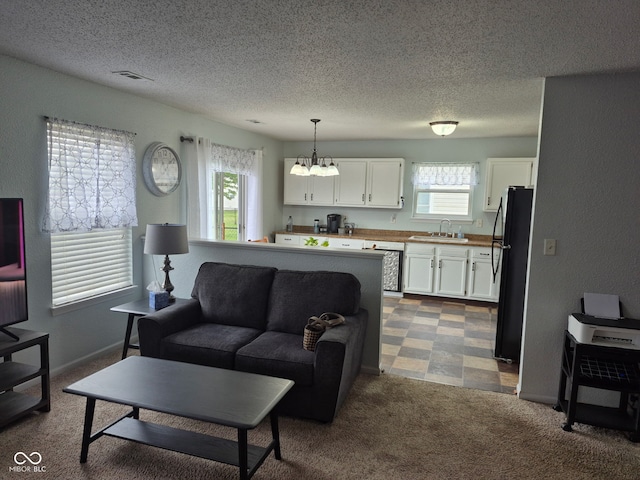 living area with baseboards, dark colored carpet, a textured ceiling, and a chandelier