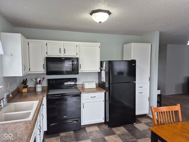 kitchen with dark countertops, a sink, a textured ceiling, white cabinetry, and black appliances