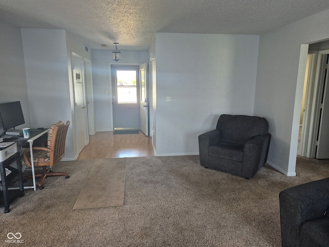 foyer entrance with baseboards, carpet flooring, and a textured ceiling