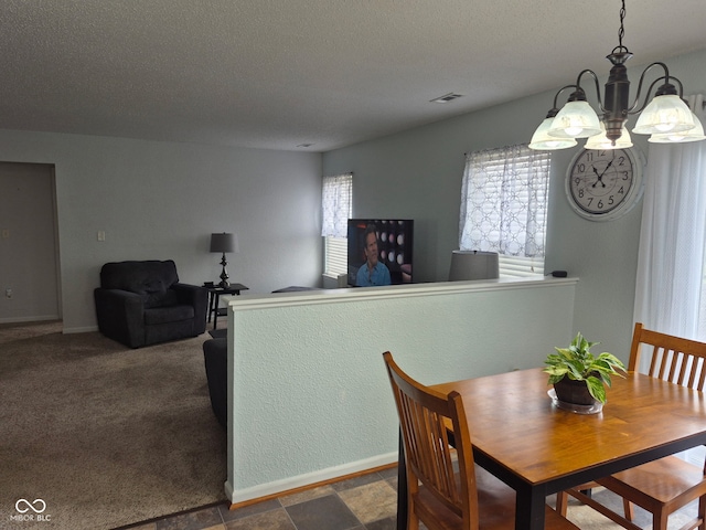 dining space featuring a textured ceiling, a chandelier, and baseboards