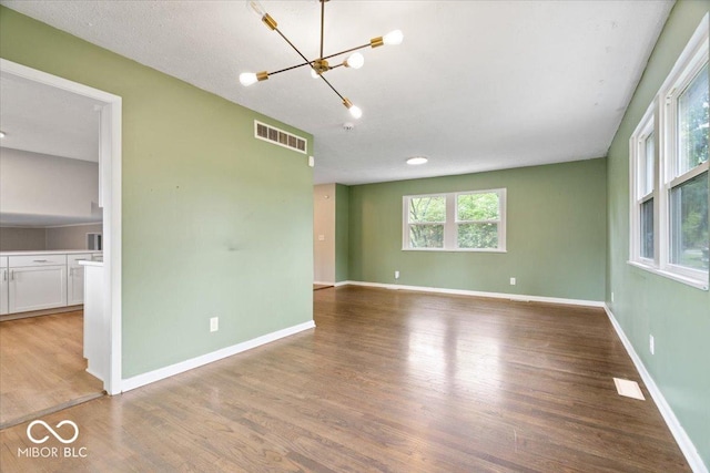 5719 Laurel Hall Dr, Indianapolis, IN 46226 - spare room with wood finished floors, a chandelier, and baseboards