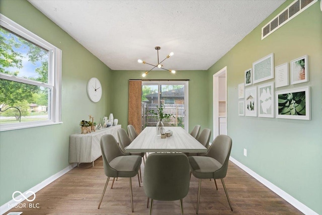 5719 Laurel Hall Dr, Indianapolis, IN 46226 - dining area with a chandelier, wood finished floors, baseboards, and a textured ceiling