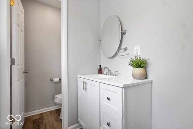 5719 Laurel Hall Dr, Indianapolis, IN 46226 - bathroom with wood finished floors, toilet, vanity, and baseboards