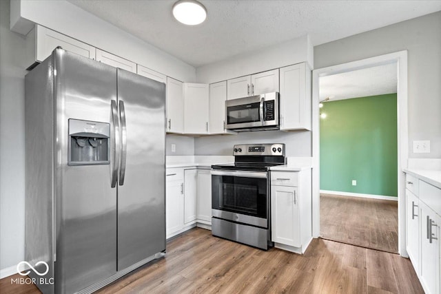 5719 Laurel Hall Dr, Indianapolis, IN 46226 - kitchen featuring stainless steel appliances, light countertops, white cabinets, and light wood-type flooring