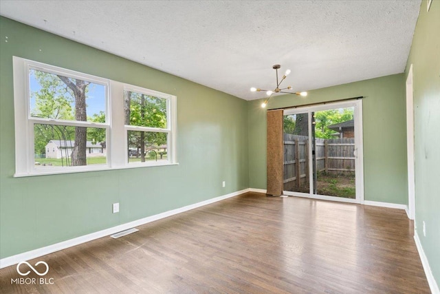 5719 Laurel Hall Dr, Indianapolis, IN 46226 - empty room with a chandelier, wood finished floors, baseboards, and a textured ceiling