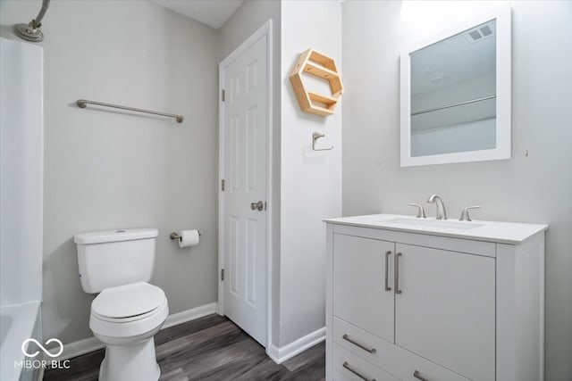 5719 Laurel Hall Dr, Indianapolis, IN 46226 - bathroom featuring wood finished floors, toilet, vanity, baseboards, and a tub to relax in