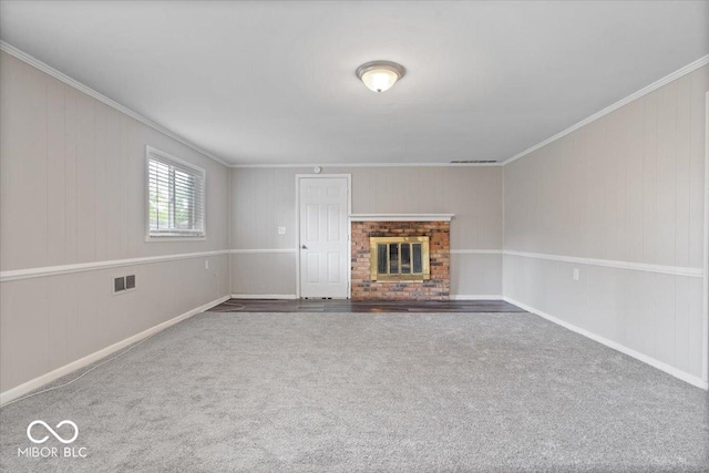 5719 Laurel Hall Dr, Indianapolis, IN 46226 - unfurnished living room featuring crown molding, carpet floors, baseboards, wooden walls, and a brick fireplace