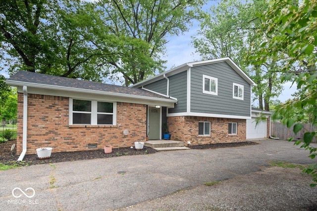 5719 Laurel Hall Dr, Indianapolis, IN 46226 - split level home with driveway, brick siding, and fence