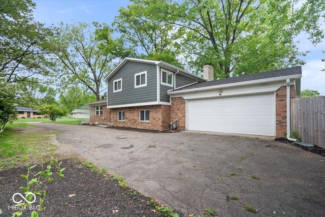 5719 Laurel Hall Dr, Indianapolis, IN 46226 - view of front of house with brick siding, driveway, an attached garage, and fence