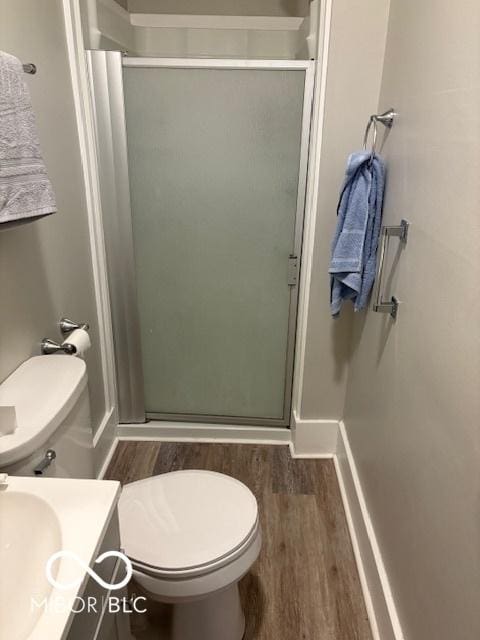 full bath with wood finished floors, a shower stall, toilet, vanity, and baseboards