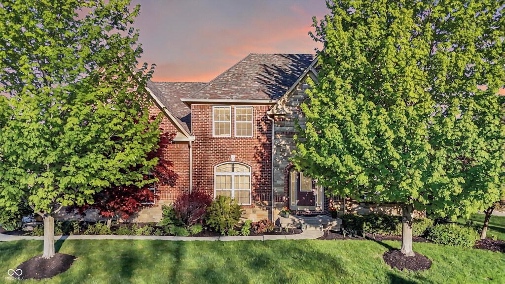 view of front of property featuring brick siding and a front lawn