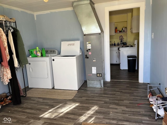 laundry room with dark wood-type flooring, washer and dryer, crown molding, and laundry area