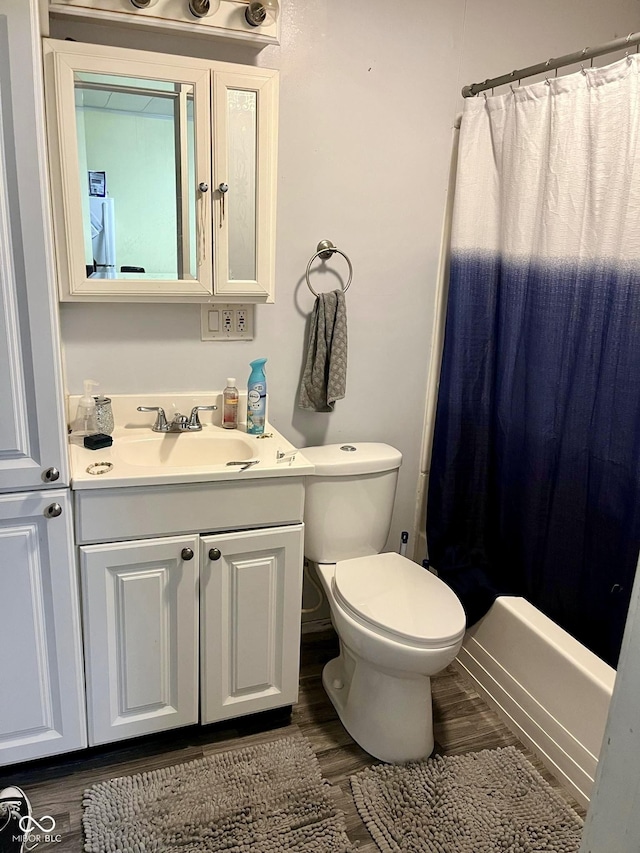 full bathroom with wood finished floors, toilet, and vanity