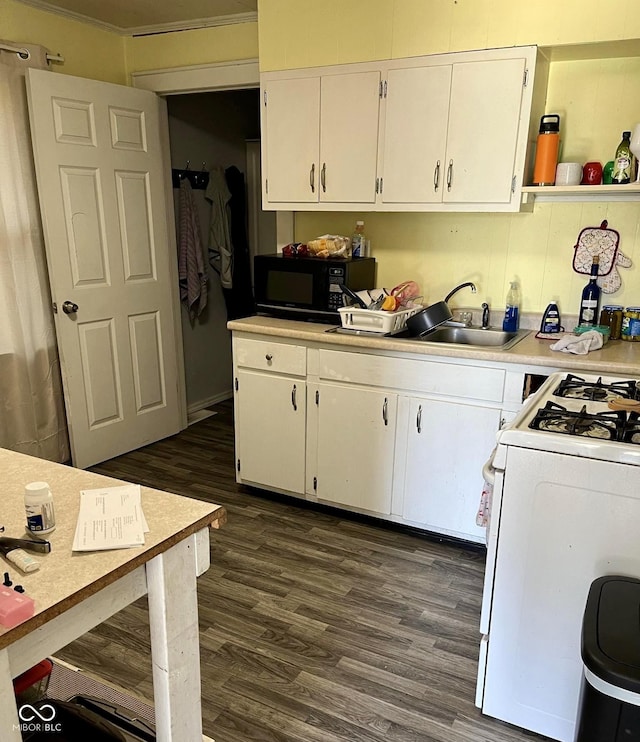 kitchen featuring white range with gas stovetop, black microwave, white cabinetry, and dark wood finished floors