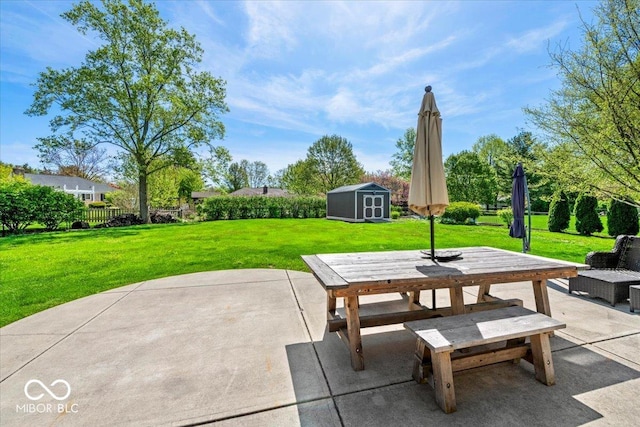 view of patio / terrace featuring fence, a shed, an outbuilding, and outdoor dining space