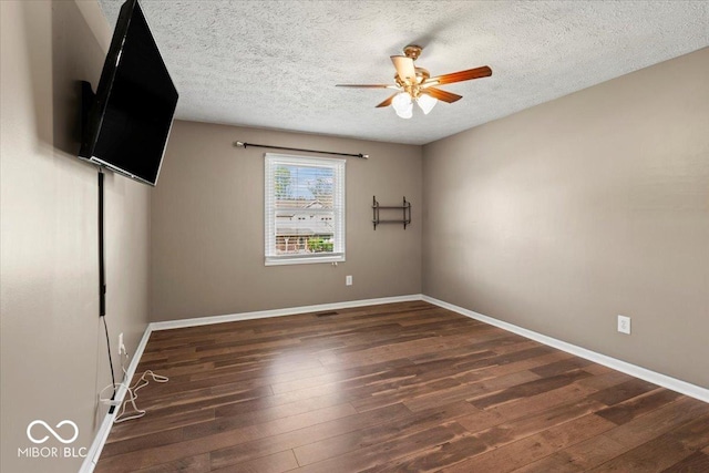 spare room with baseboards, ceiling fan, a textured ceiling, and hardwood / wood-style floors