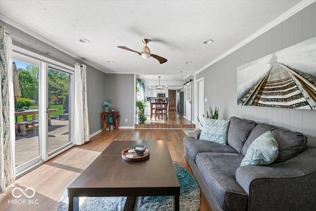 living room with a textured ceiling, ornamental molding, and wood finished floors