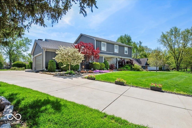 traditional-style home featuring board and batten siding, an attached garage, driveway, and a front yard